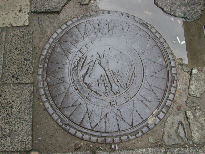 abgetretener kanaldeckel, waffe, anker oder kreuz